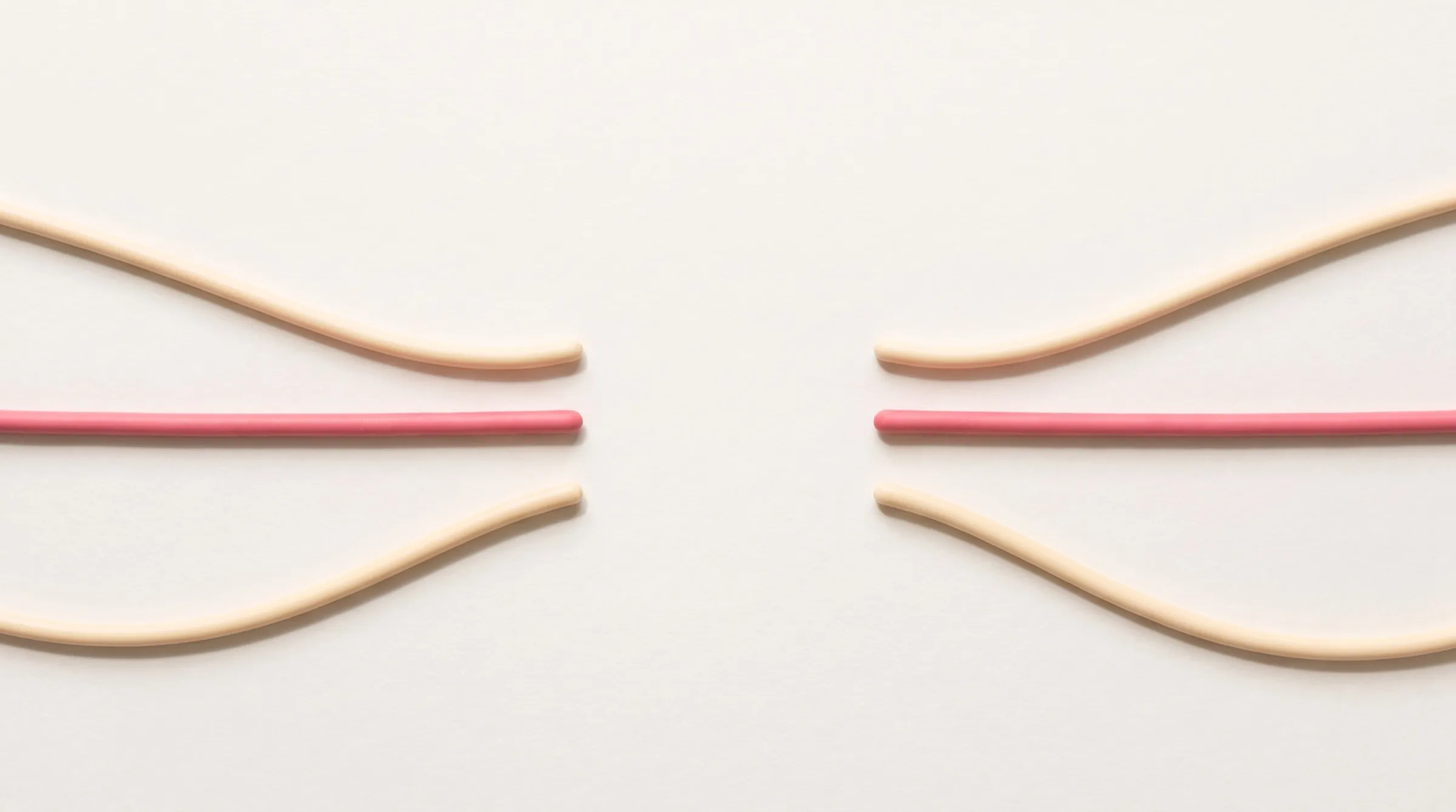 Soft cream and pink strands resting on warm paper around an empty circle